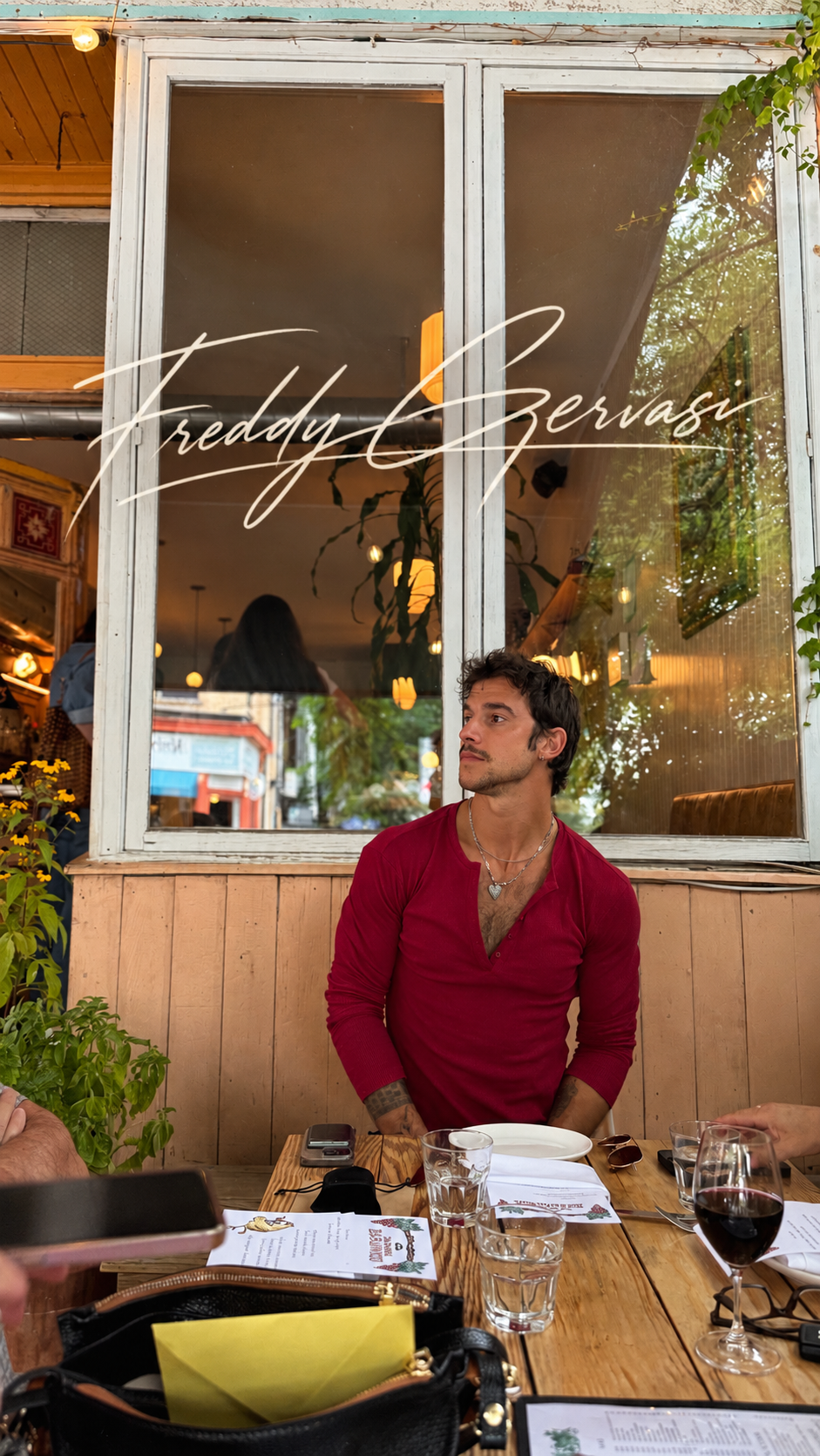Freddy in a red henley at an outdoor table